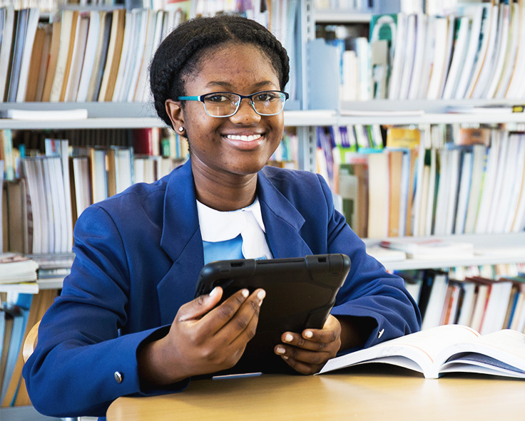 snapplify_cloud_services_pay_paragraph_image_1 - snapplify cloud services A teenager in at the library in school uniform, accessing her school work using Snapplify on a tablet device