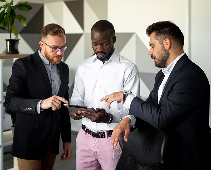 snapplify_cloud_services_origin_paragraph_image_1 - snapplify cloud services Three businessmen discussing a problem, collaborating on a tablet device